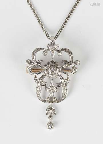 A diamond pendant brooch in a scroll pierced design, in the ...