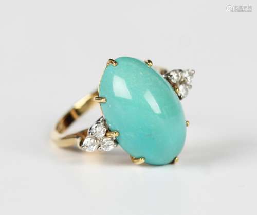 An 18ct gold ring, claw set with an oval turquoise between c...