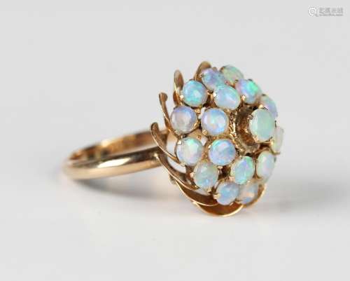 A gold and opal cluster ring, mounted with three tiers of ci...