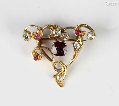 A gold, ruby, red spinel and diamond brooch in a scroll pier...