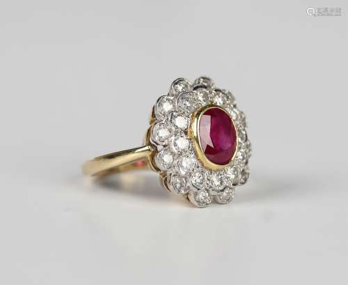 An 18ct gold, ruby and diamond cluster ring in a shaped oval...