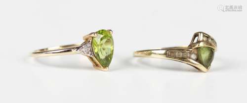 A 9ct gold ring, mounted with a trilliant cut peridot betwee...