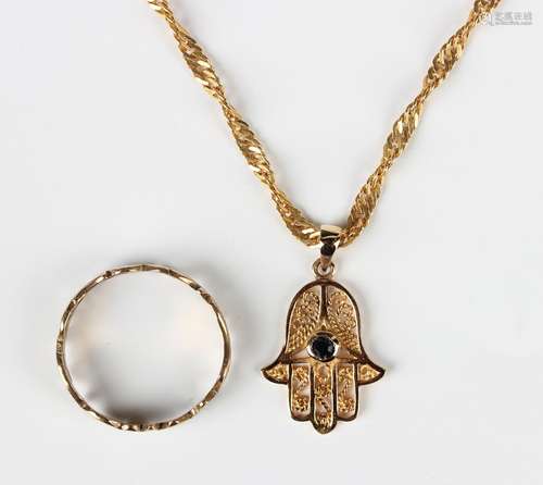 A gold filigree pendant in the form of a hand, collet set wi...