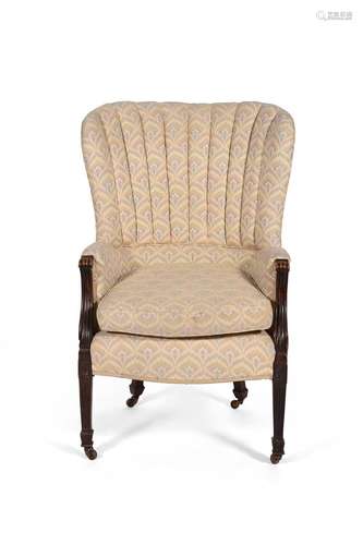 A mahogany and upholstered wing armchair in George III style