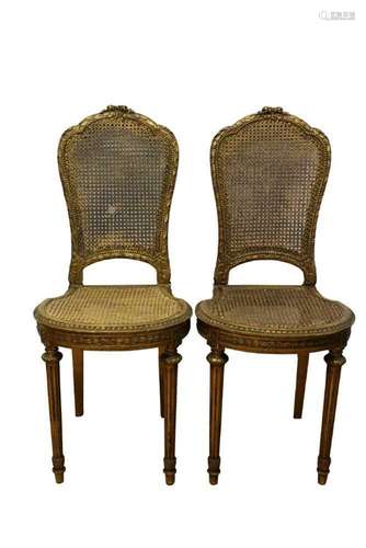 Pair of Louis XVI style gilt and caned side chairs, raised o...