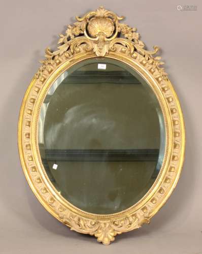 A good mid-Victorian oval gilt gesso framed wall mirror with...