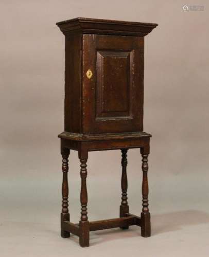 A small 17th century oak cupboard, fitted with a panelled do...
