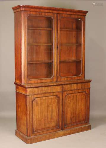 A mid-Victorian mahogany bookcase cabinet, the glazed top en...