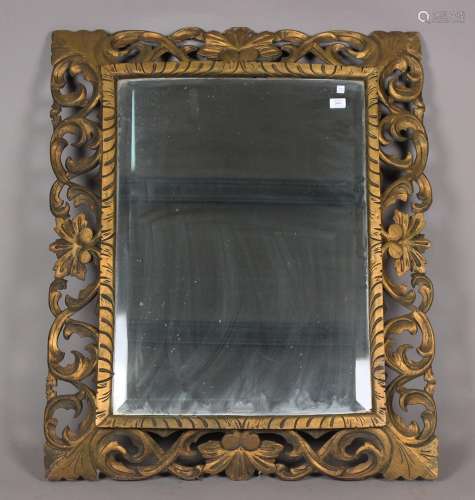 A 20th century giltwood wall mirror with a foliate scroll fr...