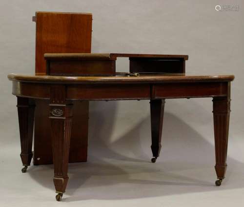A large Edwardian mahogany extending dining table, the top w...