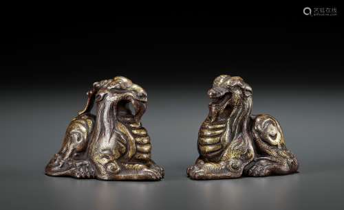 A PAIR OF GILT BRONZE ‘MYTHICAL BEAST’ WEIGHTS, EASTERN ZHOU...