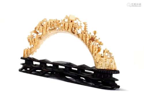 Finely carved warthog tooth bridge, depicting scenes of life...