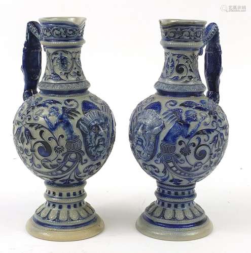 Pair of German salt glazed jugs decorated with grotesque mas...