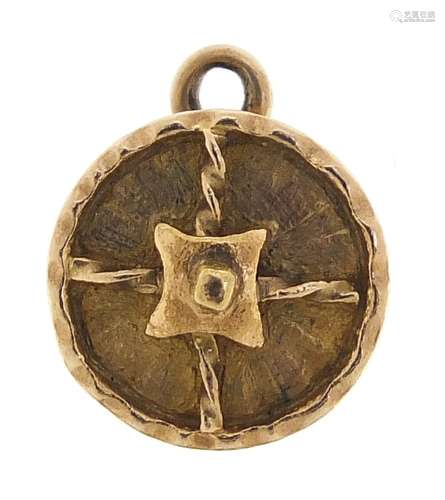 Unmarked gold shield charm, (tests as 9ct gold)1.1cm in diam...