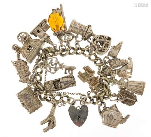 Silver charm bracelet with a selection of mostly silver char...