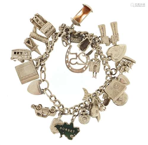 Silver charm bracelet with a selection of mostly silver char...