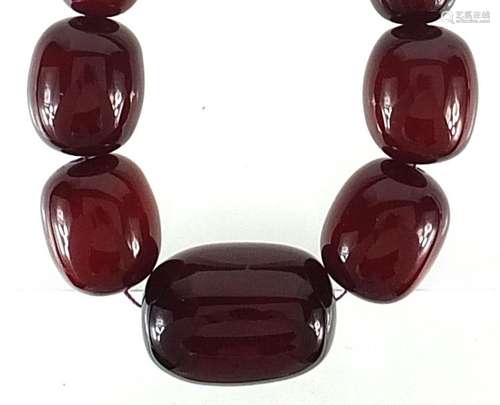 Large cherry amber coloured graduated bead necklace, the lar...