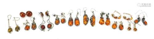 Twelve pairs of silver and natural amber earrings, the large...