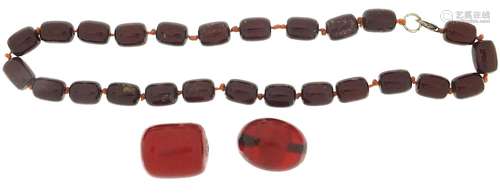 Cherry amber coloured bead necklace and two similar beads, t...