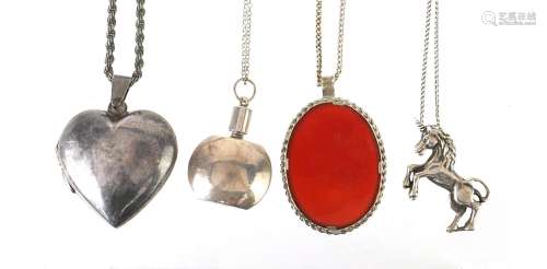 Four silver pendants on silver necklaces comprising love hea...