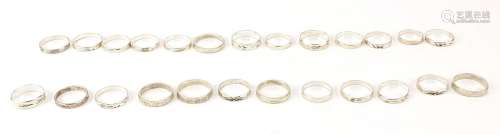 Twenty five silver coloured metal rings with engraved decora...