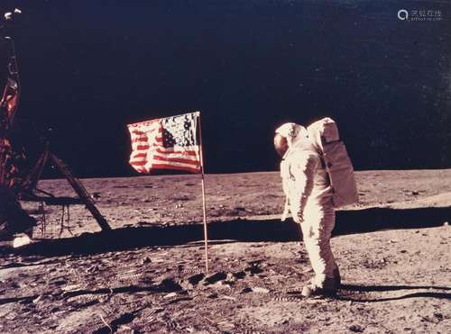 Buzz Aldrin beside the flag, his face visible in the visor [...