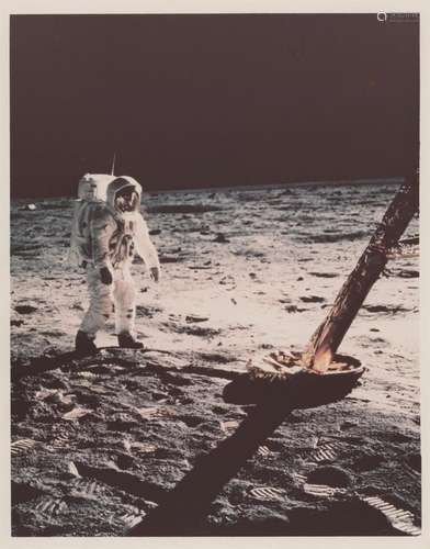 Buzz Aldrin walking by the golden footpad of the Lunar Modul...