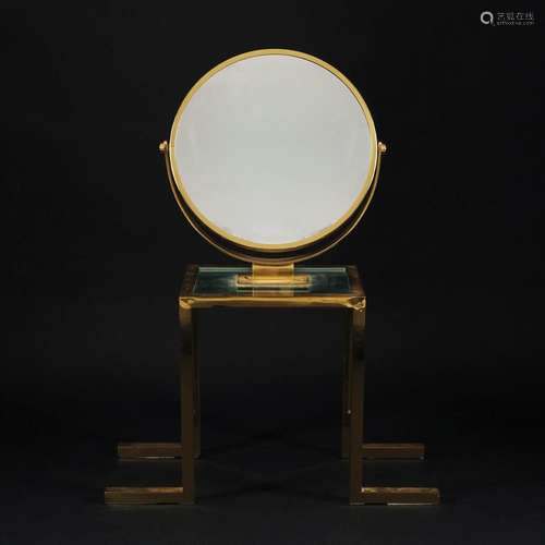 A circular gilded metal table mirror