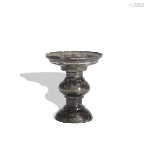 A bronze candlestick ware with gold and silver