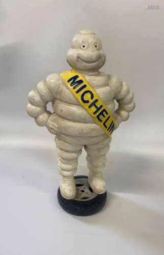 A Cast Iron Michelin Man. Vintage. Shown standing on a wheel...