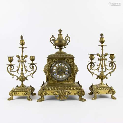 A three-piece bronze clock garniture with candlesticks