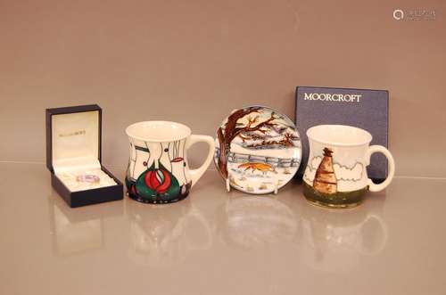 Three pieces of Moorcroft pottery, including two mugs, a sma...