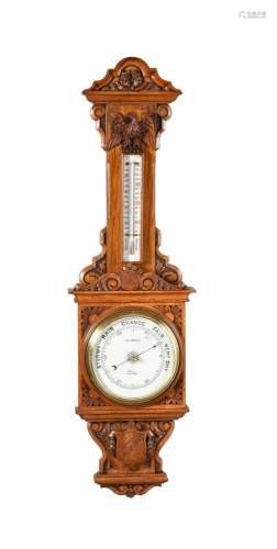 A LATE VICTORIAN CARVED OAK ANEROID WHEEL BAROMETER