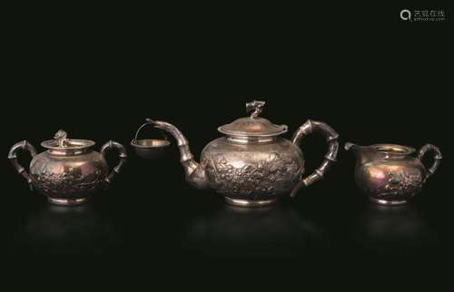 A teapot, a sugar pot with spoon and a milk jug. A silver te...