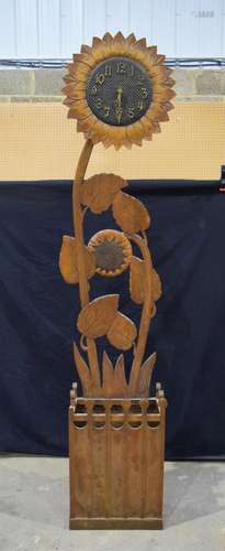 A large carved wood flower head clock and stick stand