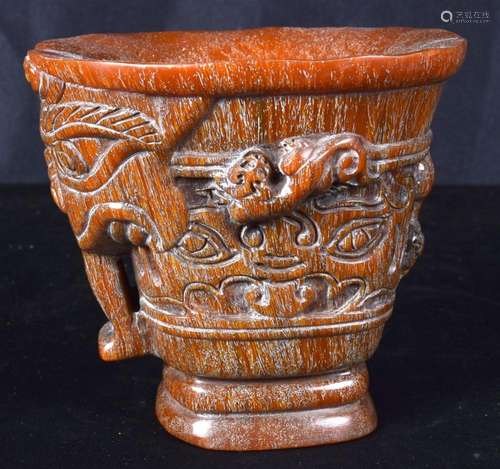 A carved horn libation cup decorated with a beast head. 11 x...