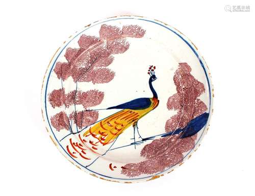 A rare Bristol Delft farmyard plate,with a peacock displayin...