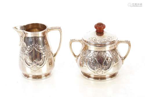 A silver cream jug,and matching sucrier, having profuse flor...