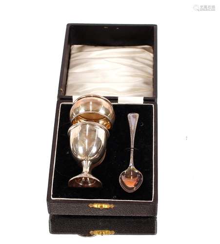 A cased silver egg cup, spoon, and napkin ring,