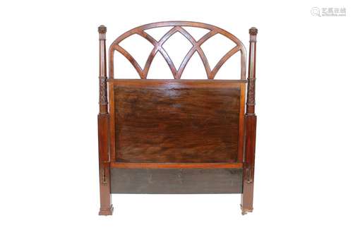 A pair of mahogany bed ends,of arched gothic design, flanked...