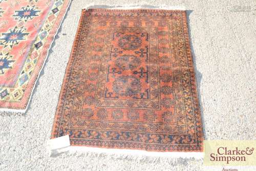 A small Bokhara rug, of traditional form on a rust