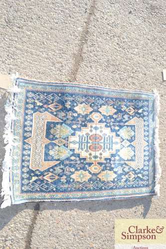 A small Eastern wool rug, stylised motifs on a pre