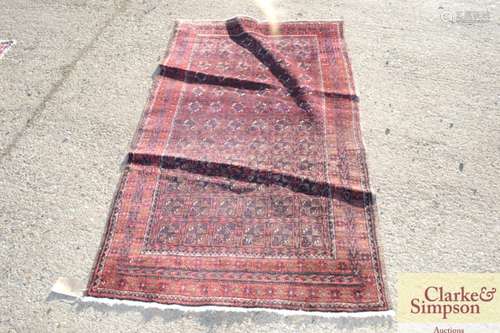 An Eastern wool rug, with stylised chequered centr