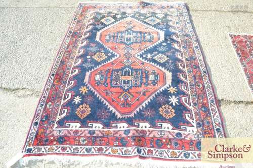 An Eastern wool rug, with central lozenge shaped m