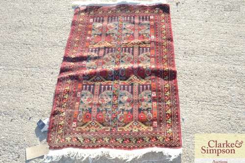 A small Eastern rug, having stylised motifs on a p