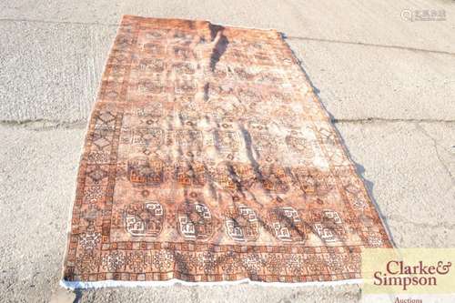 A large eastern wool rug, having gul decoration up