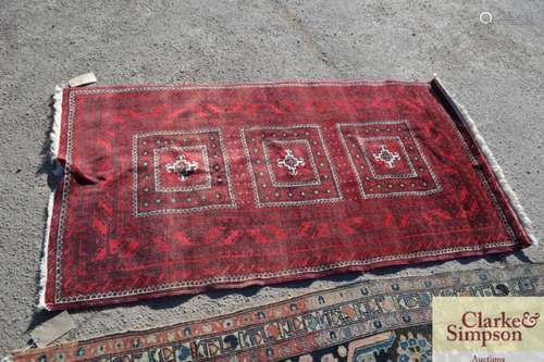 An Eastern wool rug, with stylised decoration on a