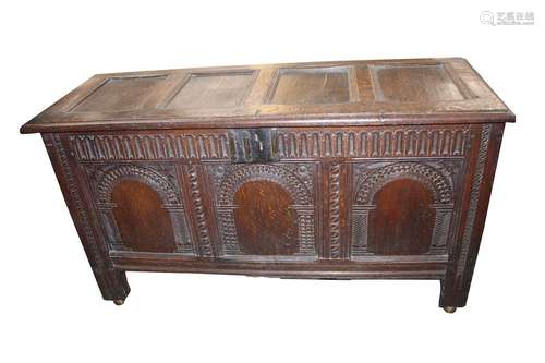 An antique oak coffer,having quadruple panelled lid above a ...