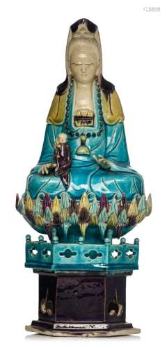 A Chinese turquoise and aubergine glazed seated Guanyin on a...