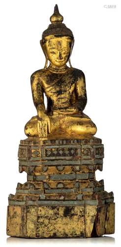 A Burmese gilt wood Buddha, seated on a two-tier lotus base,...